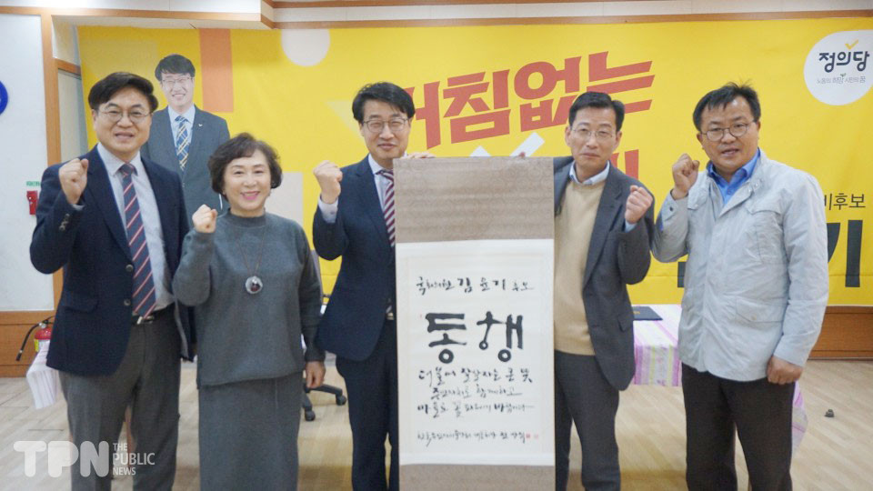 주민자치 협약 참석자들이 김윤기 후보(가운데)에게 족자를 전달한 후 기념 촬영을 하고 있다. 사진=이문재 기자